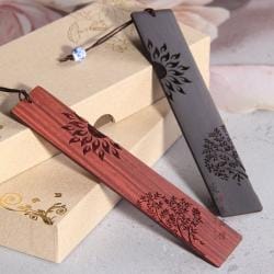 Zwei handgefertigte Lesezeichen aus Holz im chinesischen Stil mit lasergravierten Sonnen- und Baummotiven.