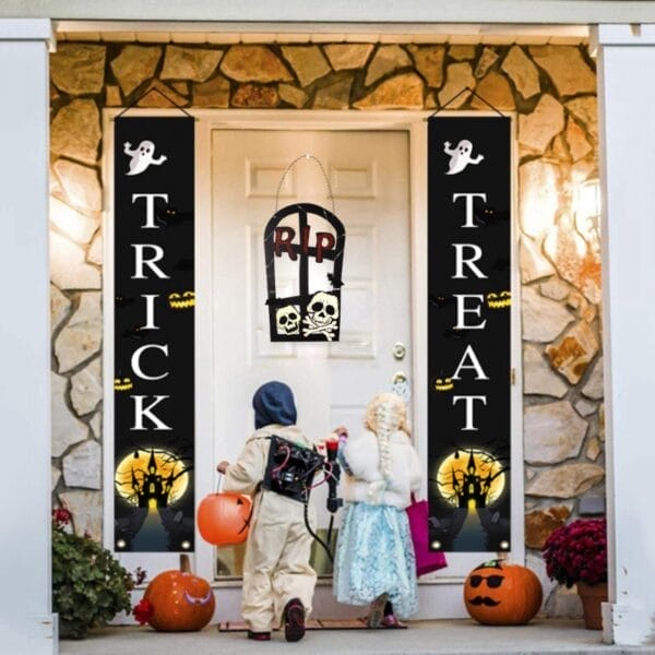 Halloween-Veranda-Dekor: „Süßes oder Saures“-Banner neben einem gruseligen Schild in Form eines Grabsteins mit der Aufschrift „RIP“.