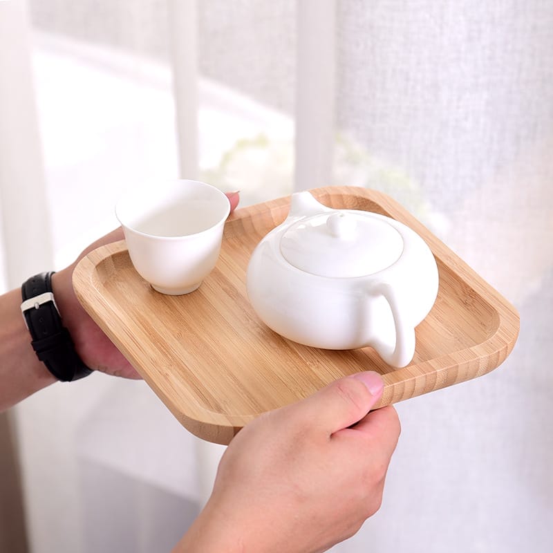 Serviertablett aus Bambus mit weißer Teekanne und Tasse. Perfekt für Teezeremonien.