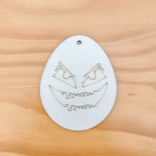 Lasergeschnittenes Halloween-Ei aus Holz mit gruseligem Gesicht. DIY-Dekoration.