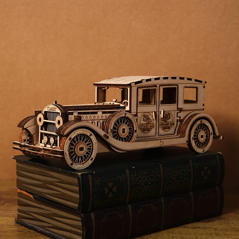 Hölzernes 3D-Puzzle-Oldtimermodell auf Büchern. „Oldtimer“-Logo sichtbar.