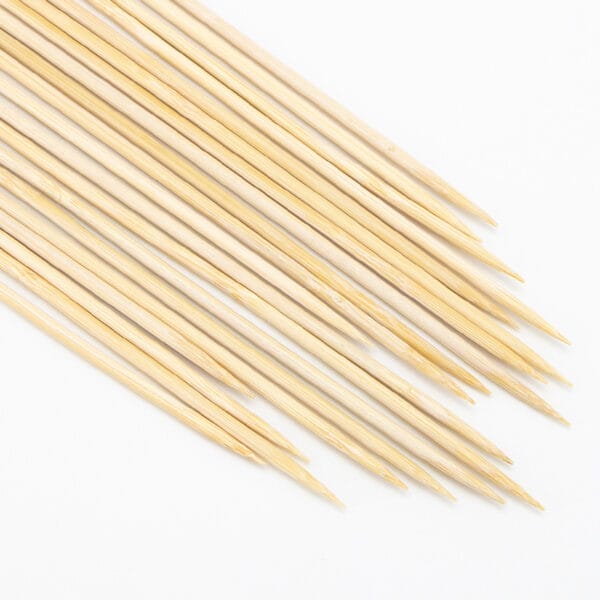 Viele biologisch abbaubare Bambusspieße auf weißem Hintergrund angeordnet. Ideal zum Grillen und für Obst.