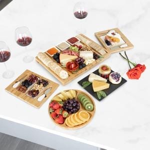Bambus-Käsebrett mit Obst und Käse auf einem Marmortisch