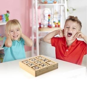 Zwei Kinder spielen ein Tic-Tac-Toe-Spiel aus Holz.