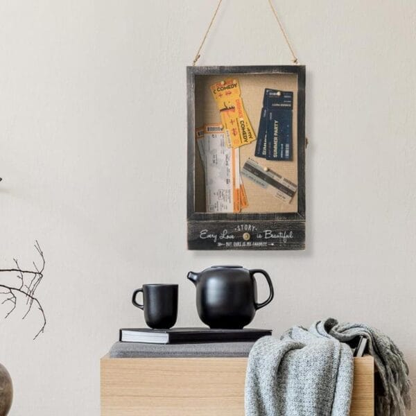 Hölzerne Erinnerungsbox mit Tickets und Karten, an der Wand hängend. "Jede Liebe ist schön