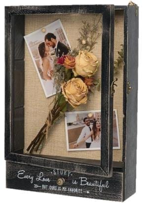Vintage-Schattenbox aus Holz mit Fotos und getrockneten Blumen. Auf der Box steht die Aufschrift „Every Love Story...But Ours Is My Favorite“.
