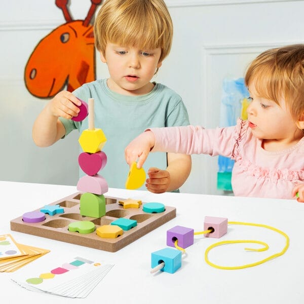 Zwei Kleinkinder spielen mit einem bunten hölzernen Formsortierer und Schnürspielzeug. Frühkindliche Bildung.