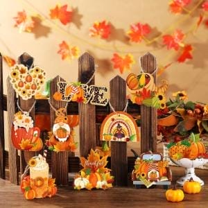 Holzzaun mit Kürbis-, Vogelscheuchen- und Ahornblatt-Dekoration für eine Halloween-Party.