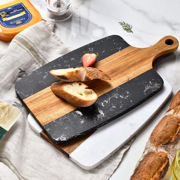 Schneidebrett aus Akazienholz und Marmor mit Brot und Erdbeeren. Hochwertiges Küchenbrett.