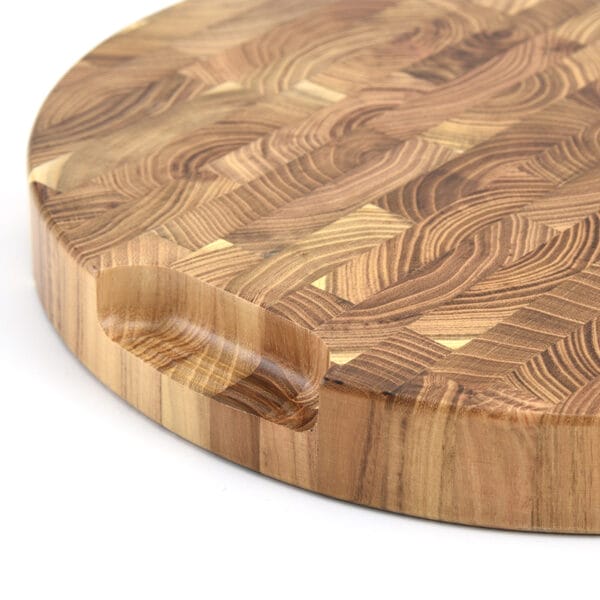 Rundes Schneidebrett aus Teakholz mit Fingergriff und geometrischem Hirnholz-Design. Ideal für den Großhandel.