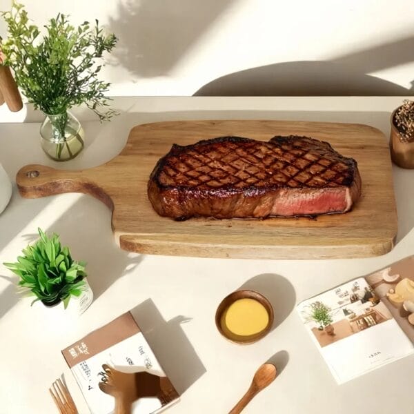 Gegrilltes Steak auf einem Schneidebrett aus Akazienholz.