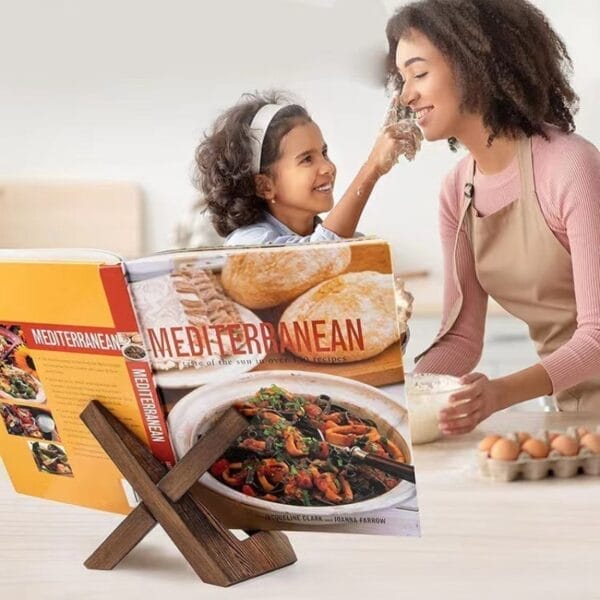 Mutter und Tochter kochen gemeinsam mediterrane Rezepte, Kochbuch im Holzständer.