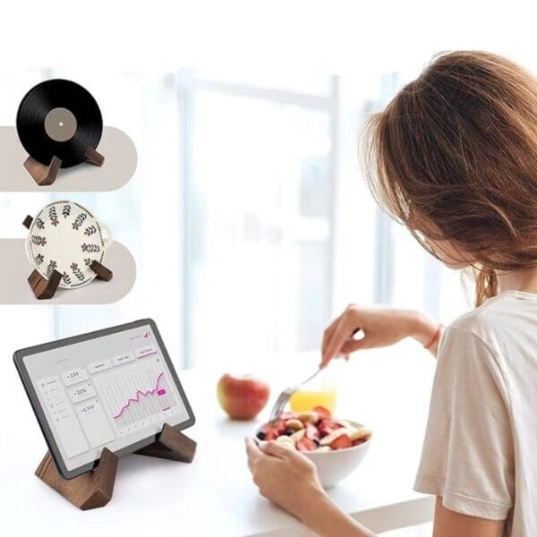 Multifunktionales Holzregal für Tablet, Teller und Schallplatte. Frau isst Obst.