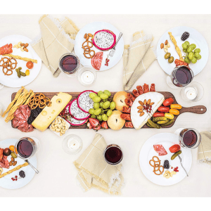 Walnuss-Käseplatte mit Wurstwaren, Obst und Weingläsern für ein Treffen