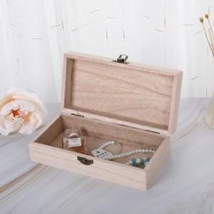Offene rechteckige Holzkiste mit Schmuck und Parfüm darin. Vintage-Holztruhe.