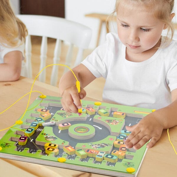 Kind spielt magnetisches Buchstabenlabyrinth. Pädagogisches Holzspielzeug.