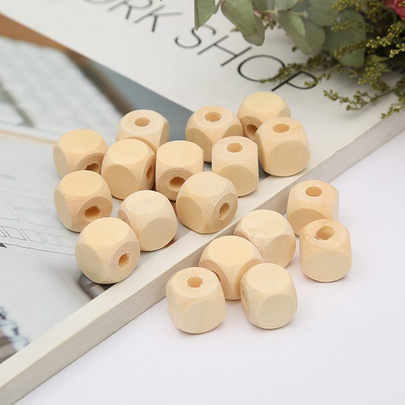 Natürliche Holzpolygonperlen mit großen Löchern auf Papierhintergrund