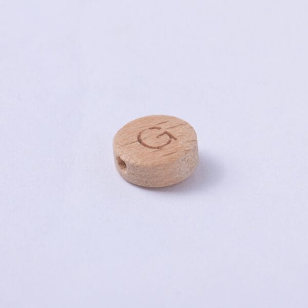 Holzperle mit dem Buchstaben G, seitlich gelocht.