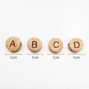 Vier Holzknöpfe mit den Buchstaben A, B, C, D.