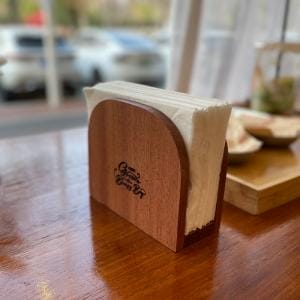 Serviettenhalter Holz auf einem Holztisch mit Servietten. Logo "Gourmet Coffee Bar