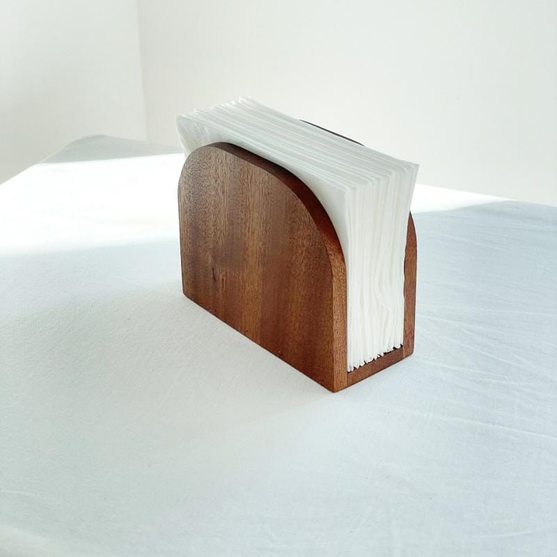 Serviettenhalter Holz mit weißen Servietten auf weißem Tisch. Stilvoller Tischhalter.