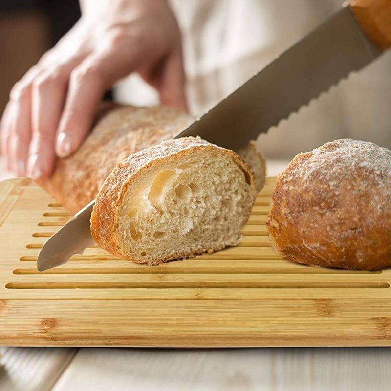 Brot schneiden auf Bambus Brotschneidebrett. Holz Brotschneidebrett im Einsatz.