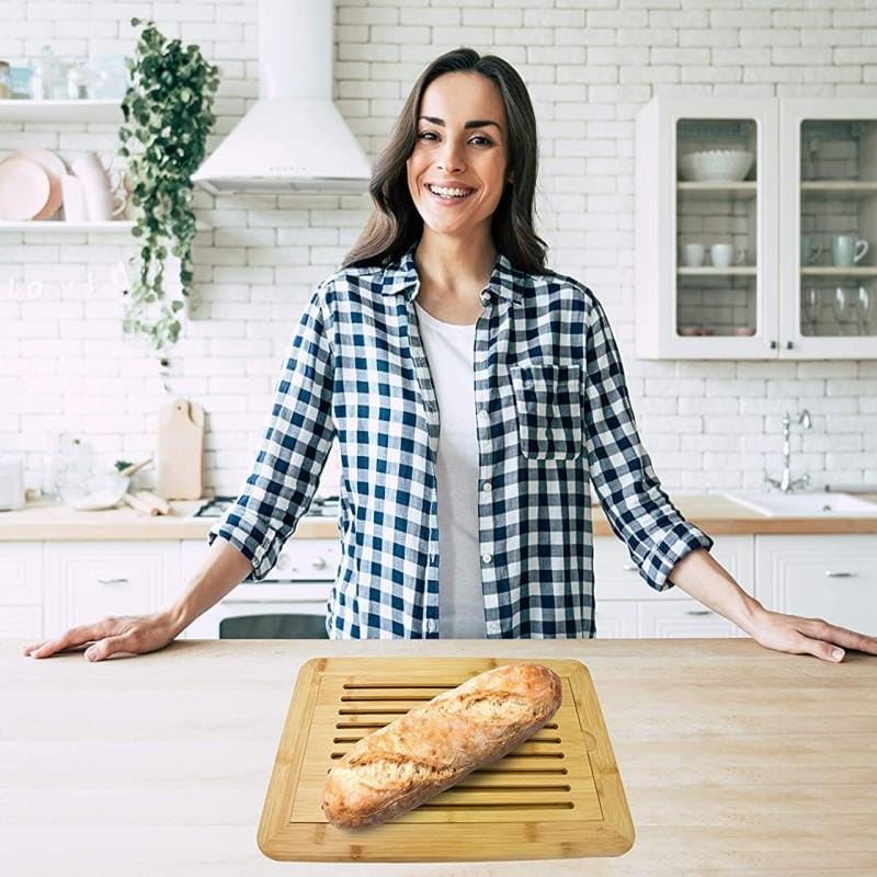 Frau präsentiert Brot auf Bambus Brotschneidebrett. Robustes Holzschneidebrett.