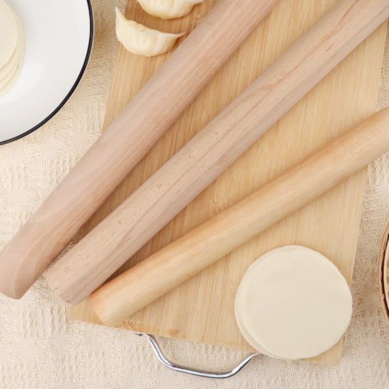 Teigroller aus Holz auf Holzbrett mit Teig für Gastronomie