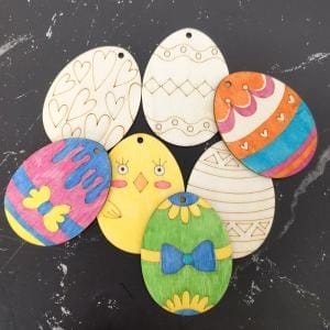 Deko Ostern Eier: Unbemalte und bemalte Holz Ostereier zum Selbstgestalten auf dunklem Hintergrund.