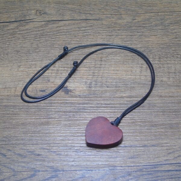 Herzförmiger Holzanhänger an schwarzer Kordel. Personalisierbarer Holzschmuck.