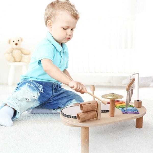Kleinkind spielt am Holz-Musikspieltisch. Nachhaltiger Spieltisch für Babys.