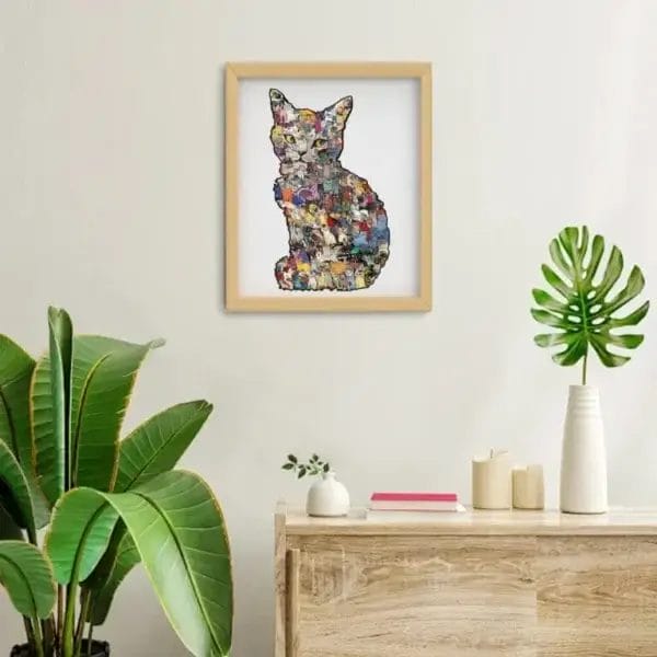 Gerahmtes Katzenpuzzle-Kunstwerk über einem Holzschrank mit Pflanzen.