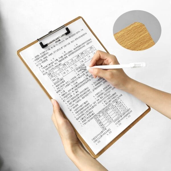 Hand schreibt auf einem Klemmbrett mit Testbogen.