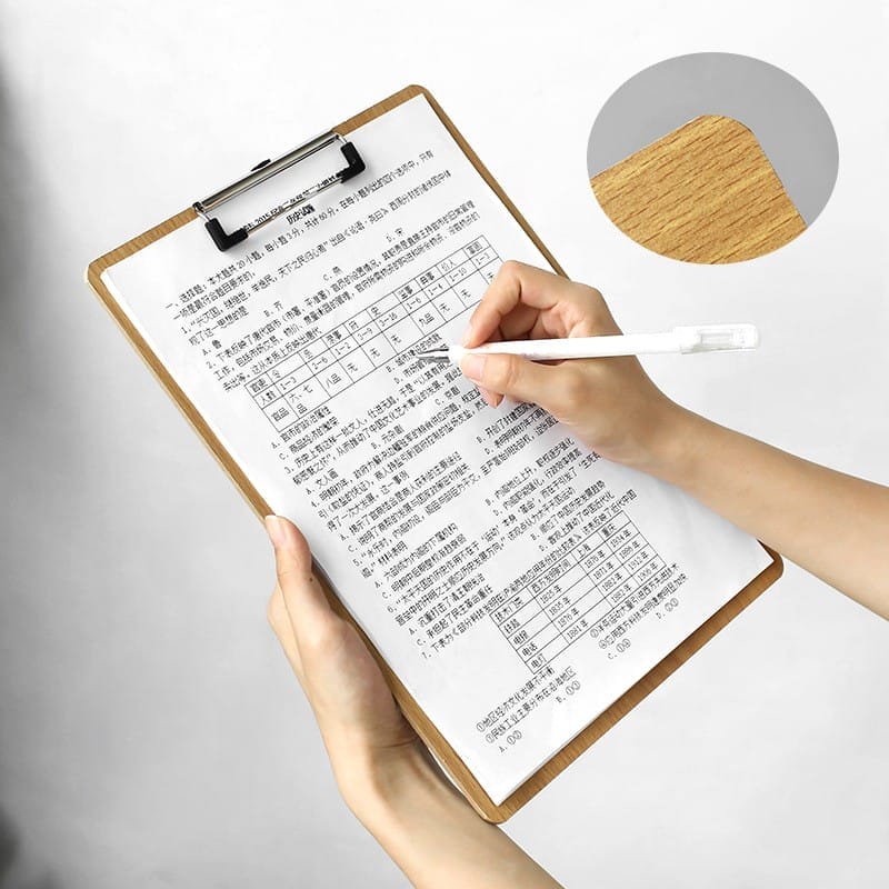 Hand schreibt auf einem Klemmbrett mit Testbogen.