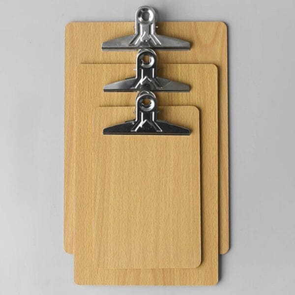 Drei hölzerne Klemmbretter unterschiedlicher Größe mit Metallklammern.