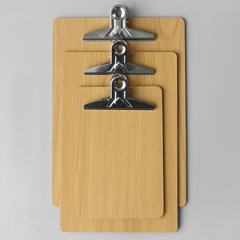 Drei hölzerne Klemmbretter unterschiedlicher Größe mit Metallklammern.