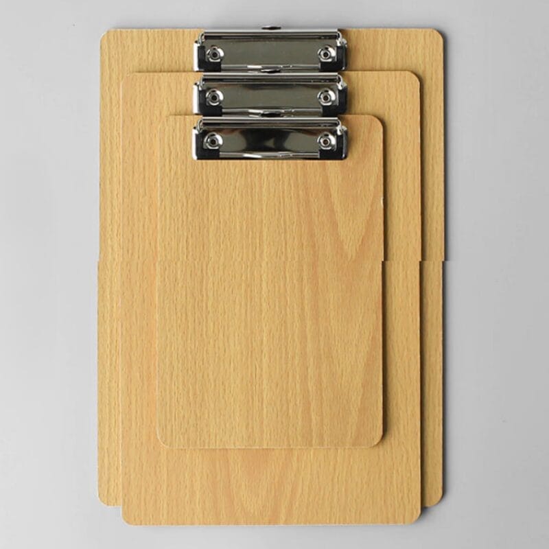 Drei hölzerne Klemmbretter unterschiedlicher Größe mit Metallklemmen.