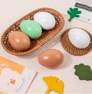 Holz Ostereier Deko in verschiedenen Farben im Korb und auf Tisch.