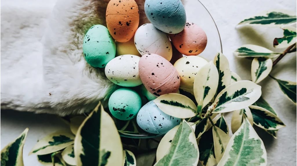 Bunte Ostereier in einer Glasschale mit Pflanze. Kreative Ostergeschenke.