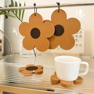 Blumenförmige Kork Untersetzer, hitzebeständig, auf einem Regal mit Tasse und Kalender.